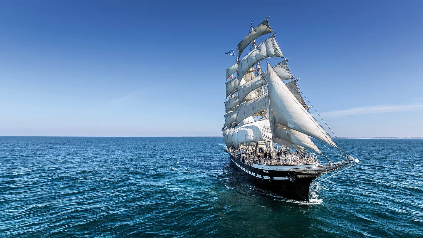 Le Belem en balade en pleine mer, toutes voiles dehors, avec l'équipage à bord.